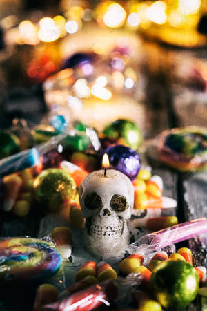 Halloween: Lit Skull Candle Surrounded By Candyの写真素材