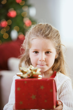 Little girl at home with Christmas tree behind, eating cookies, writing to Santa Claus, etc.
