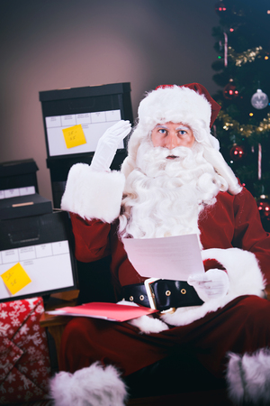Series with a man in a Santa Claus outfit, in various poses with Christmas props.の写真素材