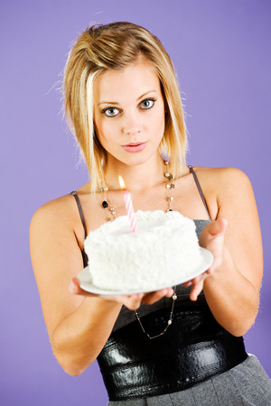 Pretty woman holding birthday cake with candle.の写真素材