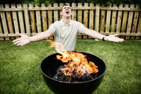 Series of an expressive man in the backyard, doing some grilling.の写真素材