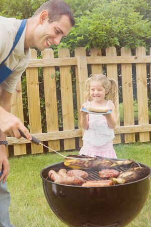 Series of an expressive man in the backyard, doing some grilling.の写真素材