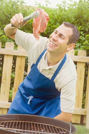 Series of an expressive man in the backyard, doing some grilling.の写真素材