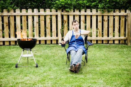 Series of an expressive man in the backyard, doing some grilling.の写真素材