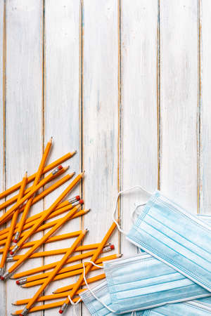 Series on weathered wood background with school items, as well as face masks and hand sanitizer for back to school.の写真素材