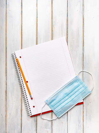 Series on weathered wood background with school items, as well as face masks and hand sanitizer for back to school.の写真素材