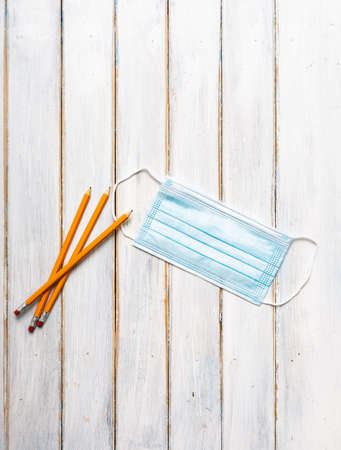 Series on weathered wood background with school items, as well as face masks and hand sanitizer for back to school.の写真素材