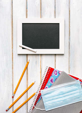 Series on weathered wood background with school items, as well as face masks and hand sanitizer for back to school.の写真素材