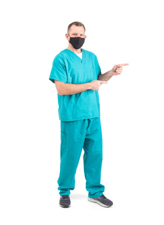 Male physician in scrubs and a mask, during the covid-19 pandemic.の写真素材