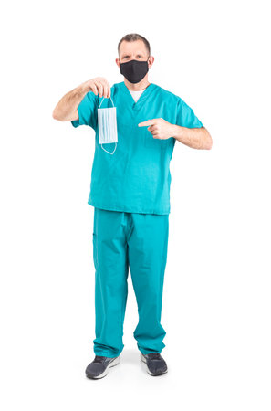 Male physician in scrubs and a mask, during the covid-19 pandemic.の写真素材