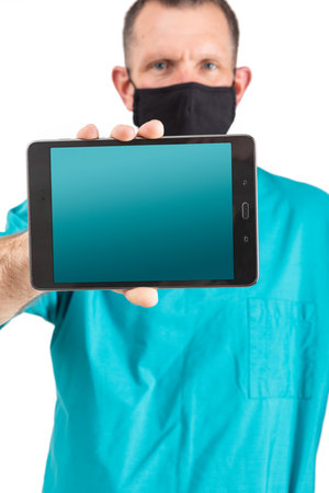 Male physician in scrubs and a mask, during the covid-19 pandemic.の写真素材