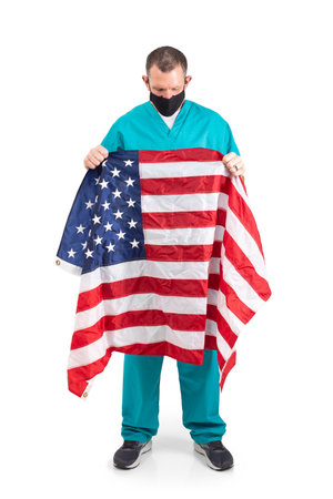 Male physician in scrubs and a mask, during the covid-19 pandemic.の写真素材