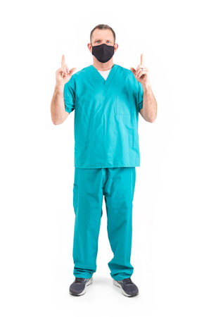 Male physician in scrubs and a mask, during the covid-19 pandemic.の写真素材