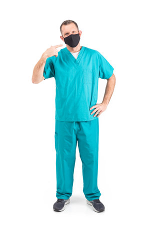 Male physician in scrubs and a mask, during the covid-19 pandemic.の写真素材