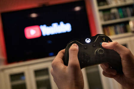 Modern, popular media and games being viewed on a large screen television through an Xbox One.のeditorial素材