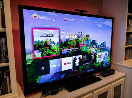 Modern, popular media and games being viewed on a large screen television through an Xbox One.のeditorial素材