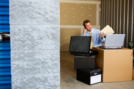 Caucasian man and woman with various props at a typical commercial storage unit.の写真素材