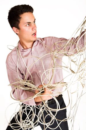 Businessman tangled up in an extension cord.の写真素材