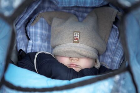 Baby in a pram with hat over his eyes.  Shallow DOF.の写真素材