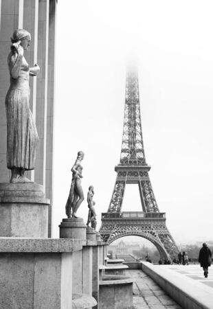 A golden statue in the foreground with the Eiffel Tower in Paris, France. Black and white.   Copy space.の写真素材