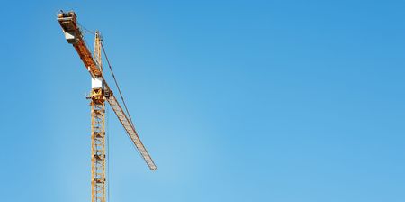 A yellow crane against the blue sky, copy space.の写真素材