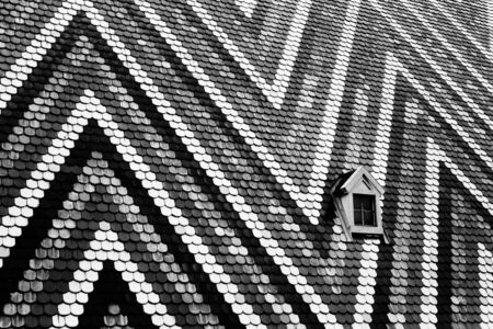 The roof and single window of St Stephens Cathedral in Vienna, Austriaの写真素材