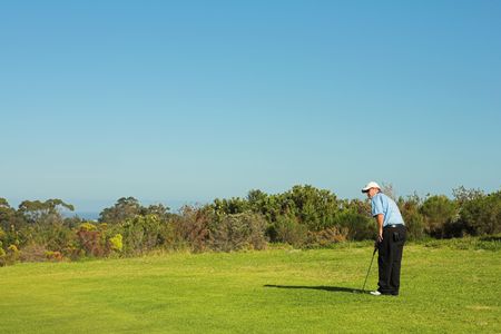 A golfer playing golf on a green.の写真素材
