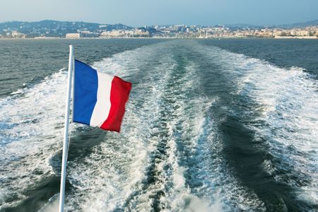 Leaving the Harbour in Cannes, France on a speedboat - French flag blowing in the windの写真素材