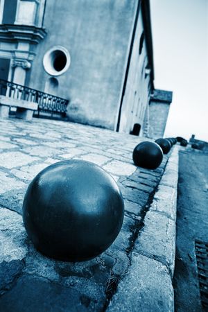 Iron balls and building in the background in Antibes, France.  Shallow D.O.F - Blue tone.の写真素材