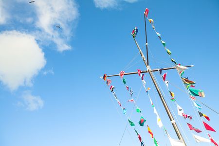 Various flags of various countries displayed together on a signal mast of a ship の写真素材