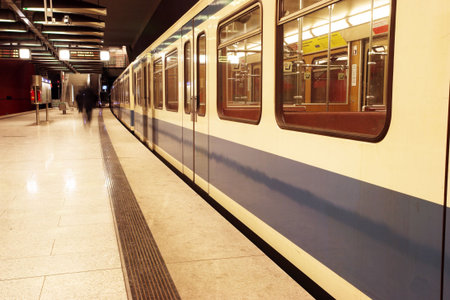 Moving train in a underground train station.  Movement on peole and train.