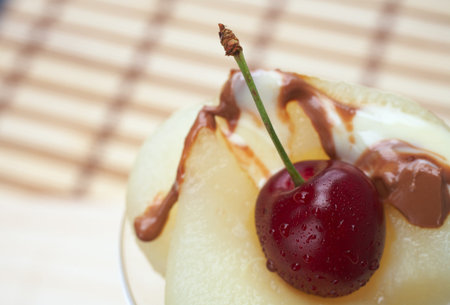 Fresh pear and cherry desert with melted white and milk chocolate toppingの写真素材