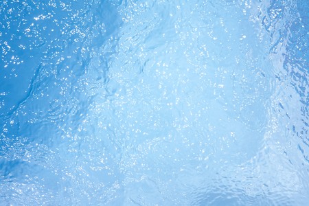 Blue texture of water in a swimming pool with specular highlightsの写真素材