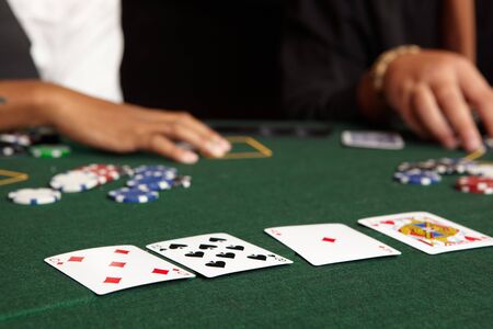 Playing cards, chips and players gambling around a green felt poker table. Shallow Depth of fieldのeditorial素材