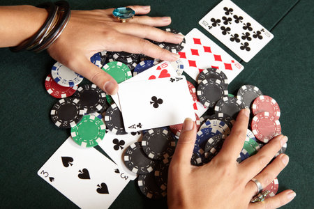 Winning hand, three of a kind, Aces high. Playing cards, chips and player pulling winnings to...