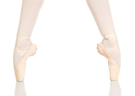 Young caucasian ballerina girl on white background and reflective white floor showing various ballet steps and positions. Not Isolatedの写真素材