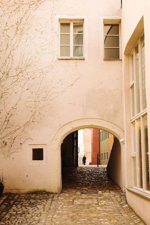 Buildings with windows and cobblestone walkway in Regensburg, Germanyの写真素材