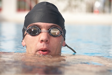 Healthy young adult male aquatic athlete. Professional swimmer in blue waterの写真素材