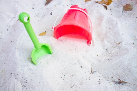 Red and green beach toys in sandの写真素材