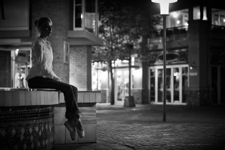 Young adult blonde ballerina dancing at night under signs and lamp posts in a general urban area の写真素材