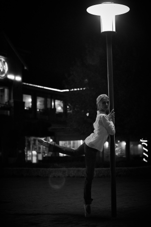 Young adult blonde ballerina dancing at night under signs and lamp posts in a general urban area  Shallow Depth of Field and in black and white  Textured and Grungyの写真素材