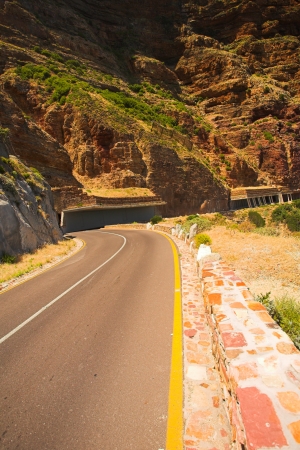 The winding road on Chapmans Peak, South Africa through the half tunnel の写真素材