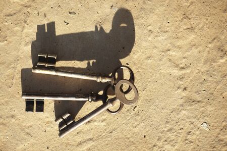 Old rusted keys on a brown tile lying in the sun - copy spaceの写真素材