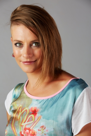 Beautiful young adult blonde caucasian woman with an funky modern hair cut on a neutral backgroundの写真素材