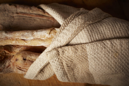 Fresh homemade traditional Moroccan bread loaves wrapped in a rough cotton cloth on a cutting board