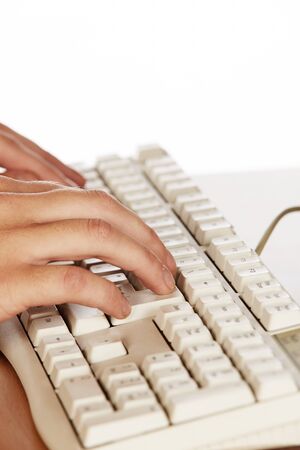 Beautiful and sexy young adult caucasian businesswoman with honey blonde hair wearing a casual business outfit working on a computer with her hands on a keyboardの写真素材