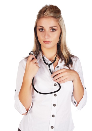 Beautiful young adult caucasian medical doctor with honey blonde hair wearing a casual white outfit and with a stethoscope in her hands against a white backgroundの写真素材
