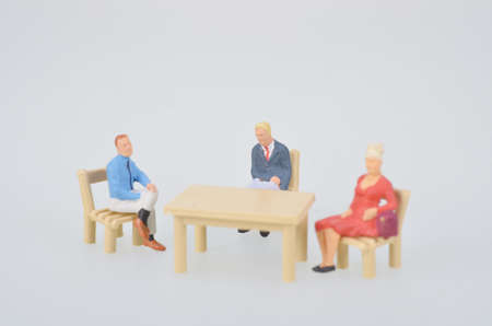 small figure sitting around tableの写真素材