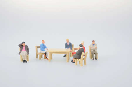 small figure sitting around tableの写真素材