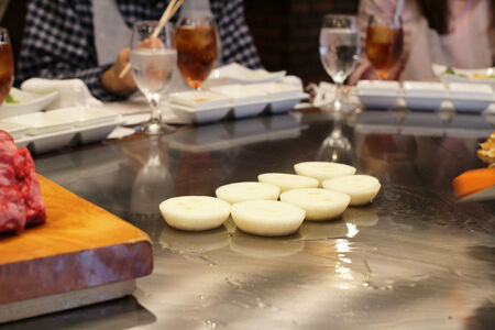 Japanese chef deliberately preparing and cooking traditional beef teppanyaki on a hot plateの写真素材